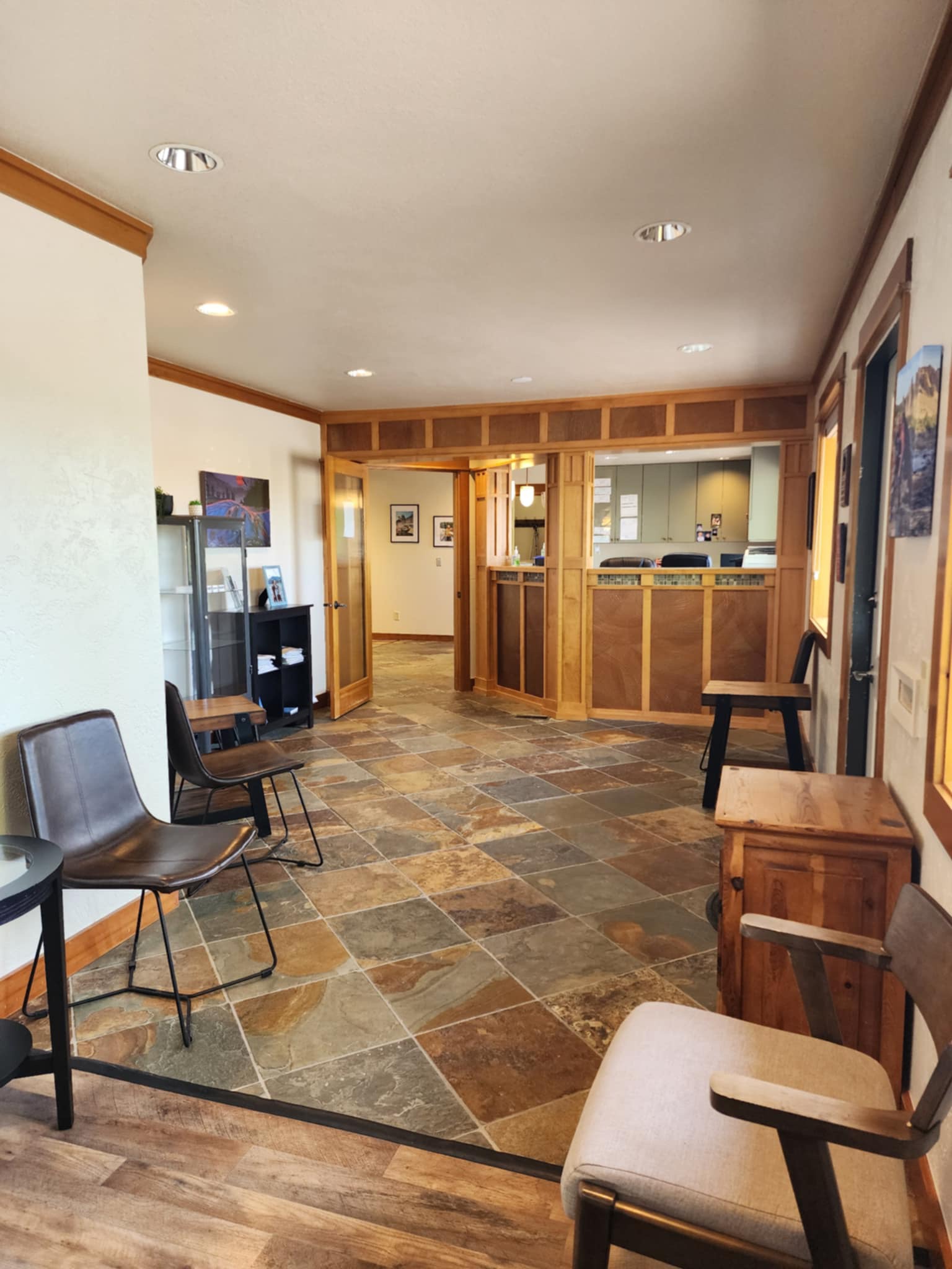 Waiting area at Sunrise Dental Longview office featuring modern chairs, slate tile flooring, and a wooden reception desk